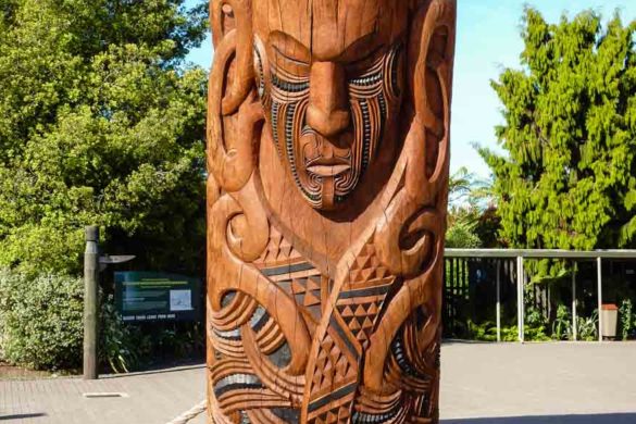 Ein mit Schnitzkunst versehener Stamm, Maorikunst im Buried Village in Rotorua auf der Nordinsel Neuseelands