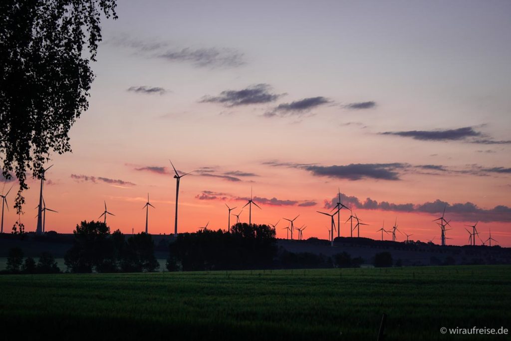 Sonnenaufgang in Wangenheim in Thüringen mit Windrädern am Horizont